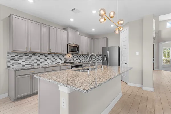 a kitchen with kitchen island granite countertop a sink appliances cabinets and counter space