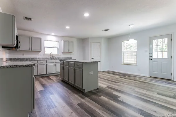 a kitchen with stainless steel appliances granite countertop a stove a sink dishwasher and a refrigerator