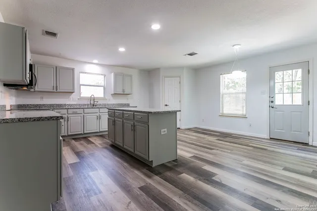 a kitchen with stainless steel appliances granite countertop a stove a sink dishwasher and a refrigerator