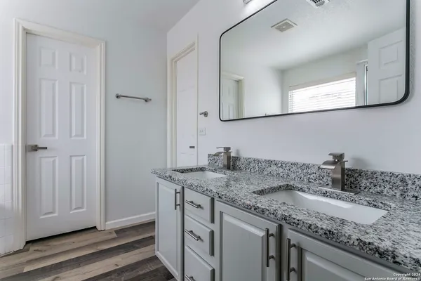 a bathroom with a granite countertop sink and a mirror
