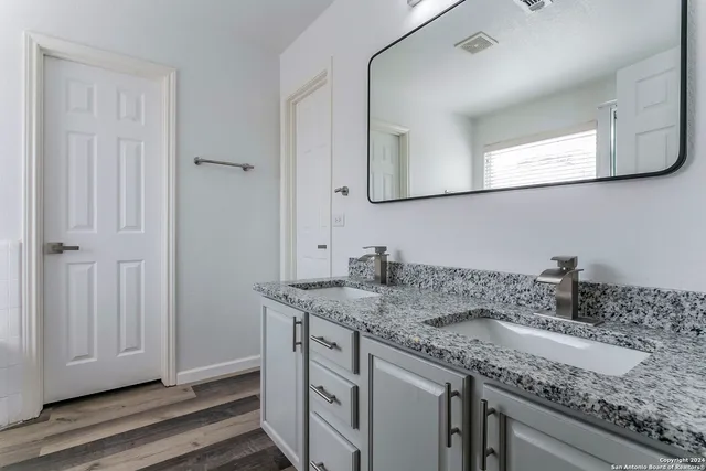 a bathroom with a granite countertop sink and a mirror