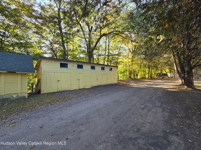 a view of a house with a large tree and wooden fence