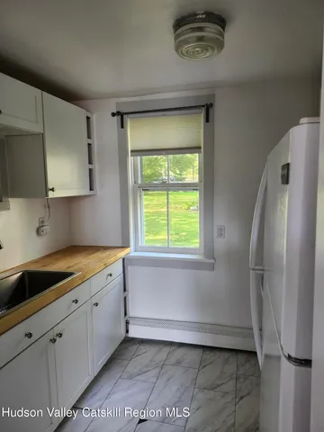 a kitchen with a refrigerator a sink and a window