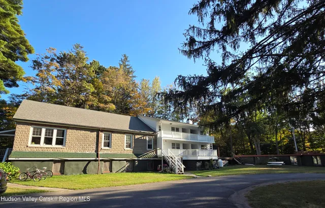 a front view of a house with a garden and tree