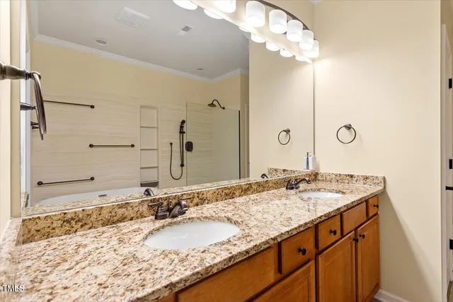 a bathroom with a granite countertop double vanity sink and a mirror
