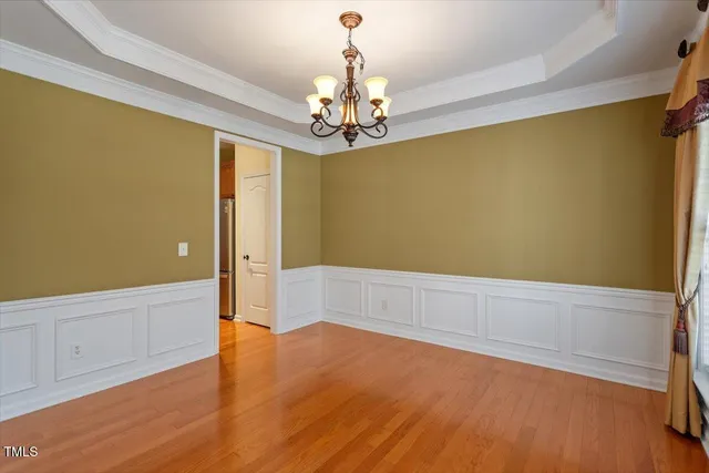 a view of a room with wooden floor and chandelier