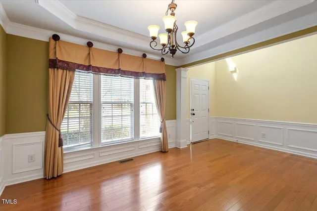a view of a livingroom with a chandelier curtains and large windows