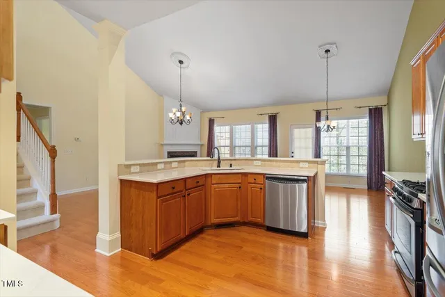 a large kitchen with stainless steel appliances granite countertop a sink stove and wooden floor
