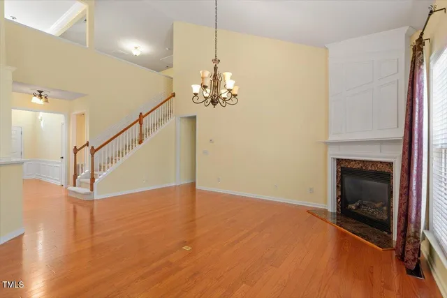 a view of a livingroom with wooden floor and a fireplace