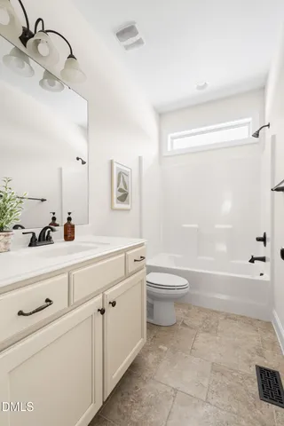a bathroom with a double vanity sink a toilet and a shower