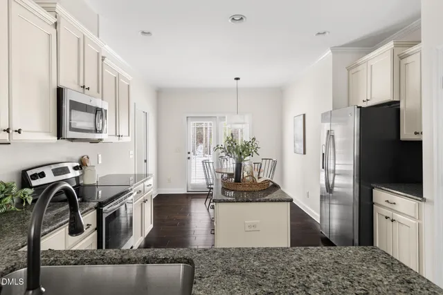 a kitchen with stainless steel appliances granite countertop a refrigerator a stove and a sink