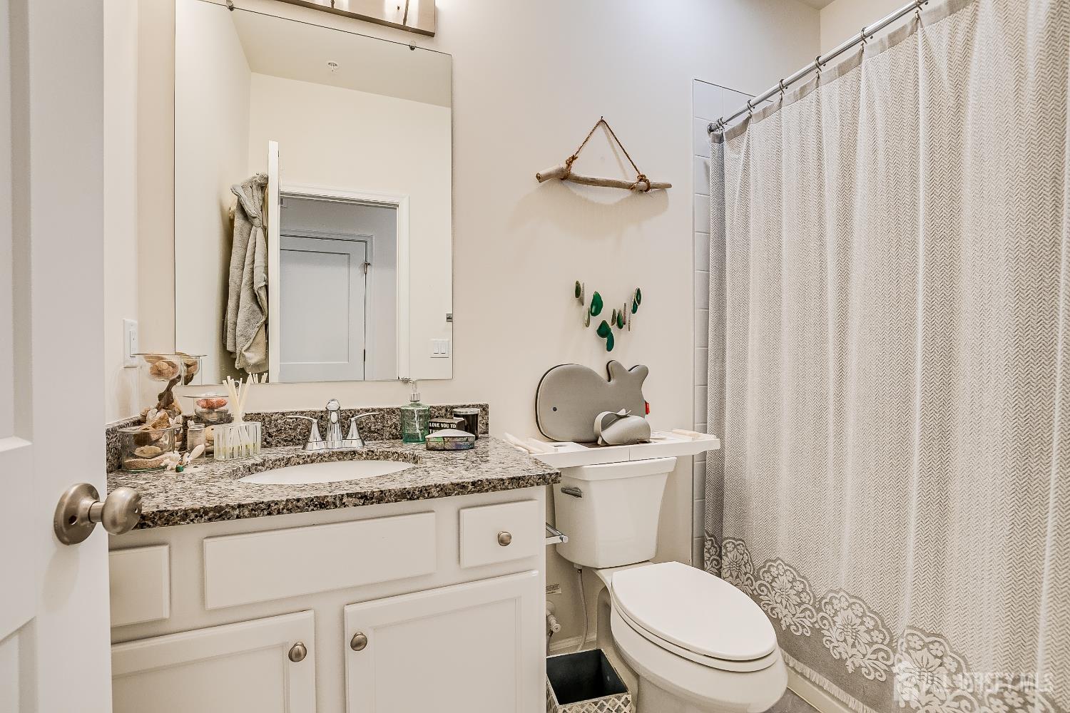 224 Park Lane Dunellen, NJ 08812 - Photo 27 of 40 a bathroom with a granite countertop sink vanity mirror and toilet