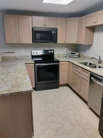 a kitchen with granite countertop a stove top oven a sink dishwasher and white cabinets
