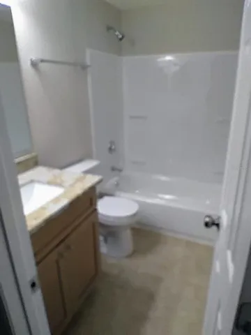 a bathroom with a granite countertop toilet a sink and bathtub