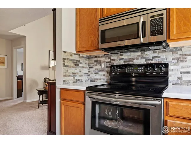 a kitchen with stainless steel appliances granite countertop a stove microwave and cabinets