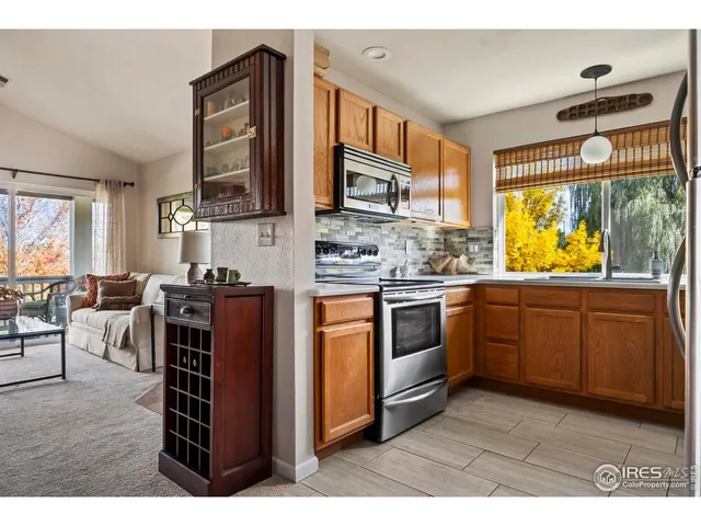 a kitchen with stainless steel appliances granite countertop a stove top oven a sink a dining table and chairs