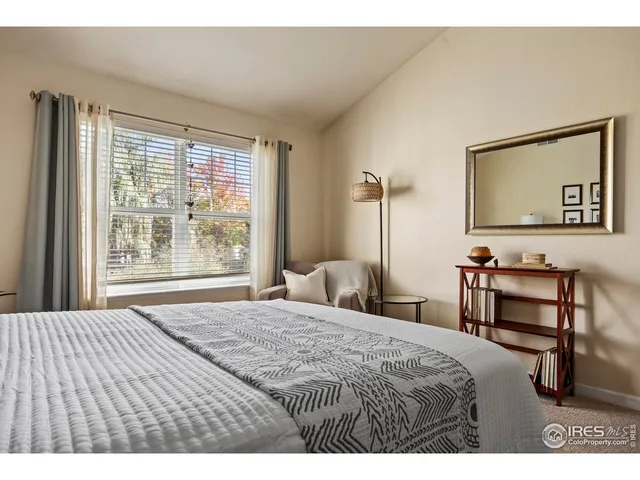 a bedroom with a bed table and a window