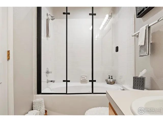 a bathroom with a tub sink and mirror