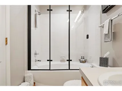 a bathroom with a tub sink and mirror