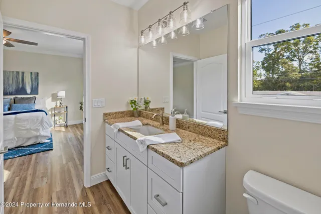 a spacious bathroom with a granite countertop sink and a mirror