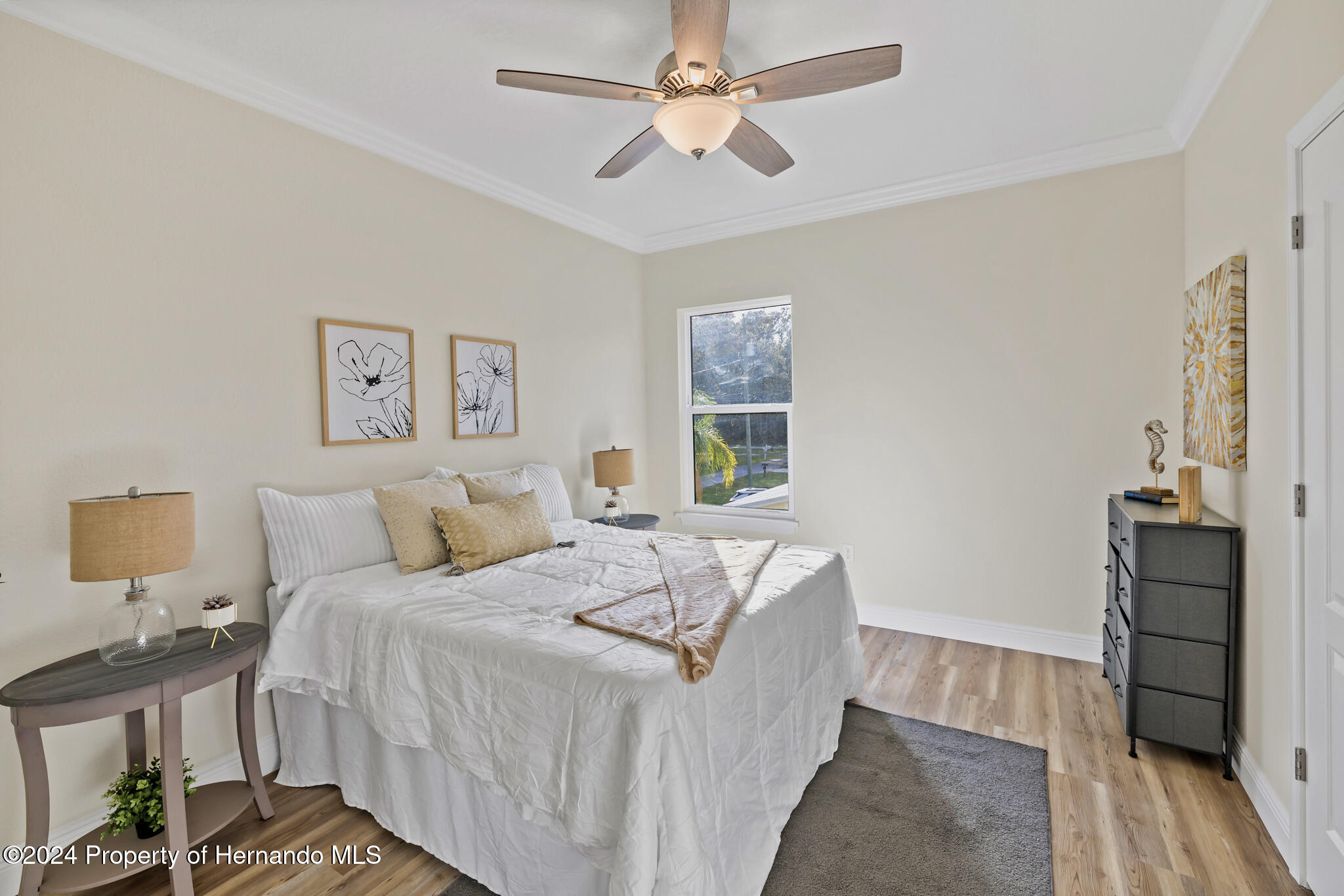 6435 Finance Avenue Weeki Wachee, FL 34607 - Photo 17 of 35 a bedroom with a bed and wooden floor
