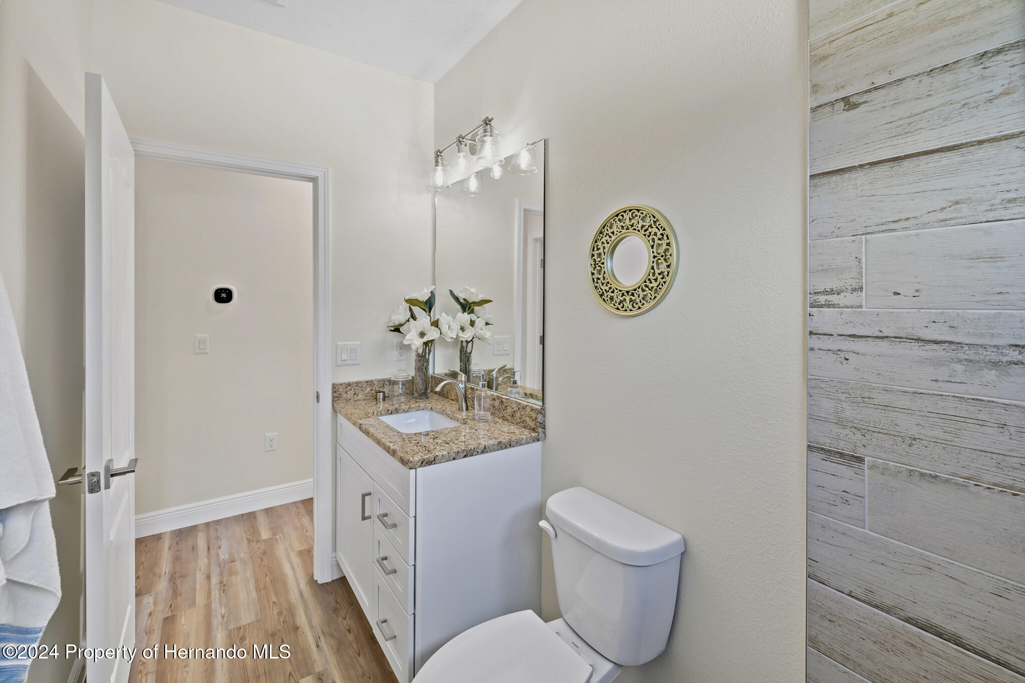 6435 Finance Avenue Weeki Wachee, FL 34607 - Photo 21 of 35 a spacious bathroom with a toilet a sink and a mirror