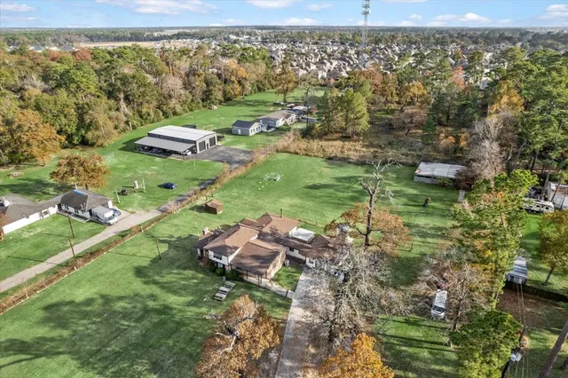 an aerial view of residential houses with outdoor space and trees