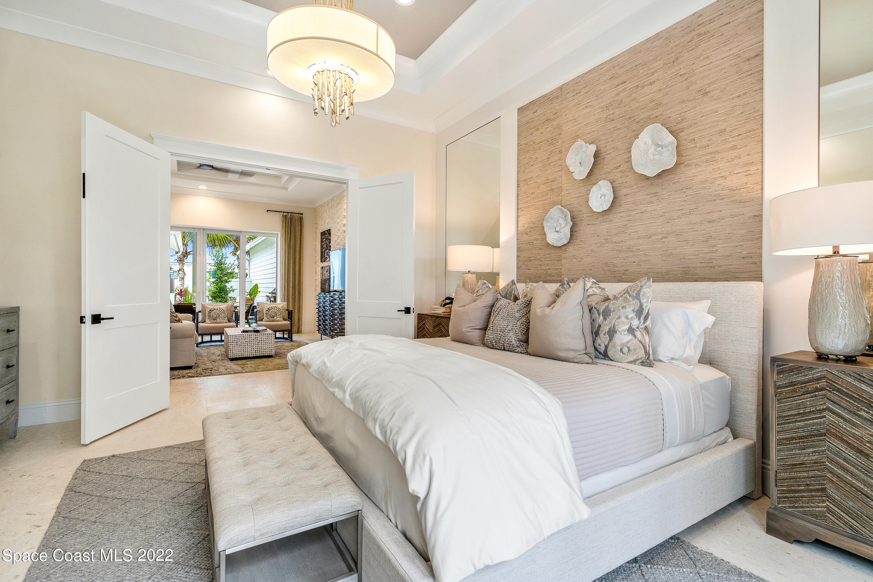 20 Strand Drive Vero Beach, FL 32963 - Photo 18 of 36 a bedroom with a large bed and a chandelier