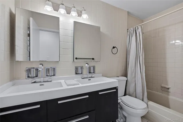 a bathroom with a sink toilet double vanity and shower