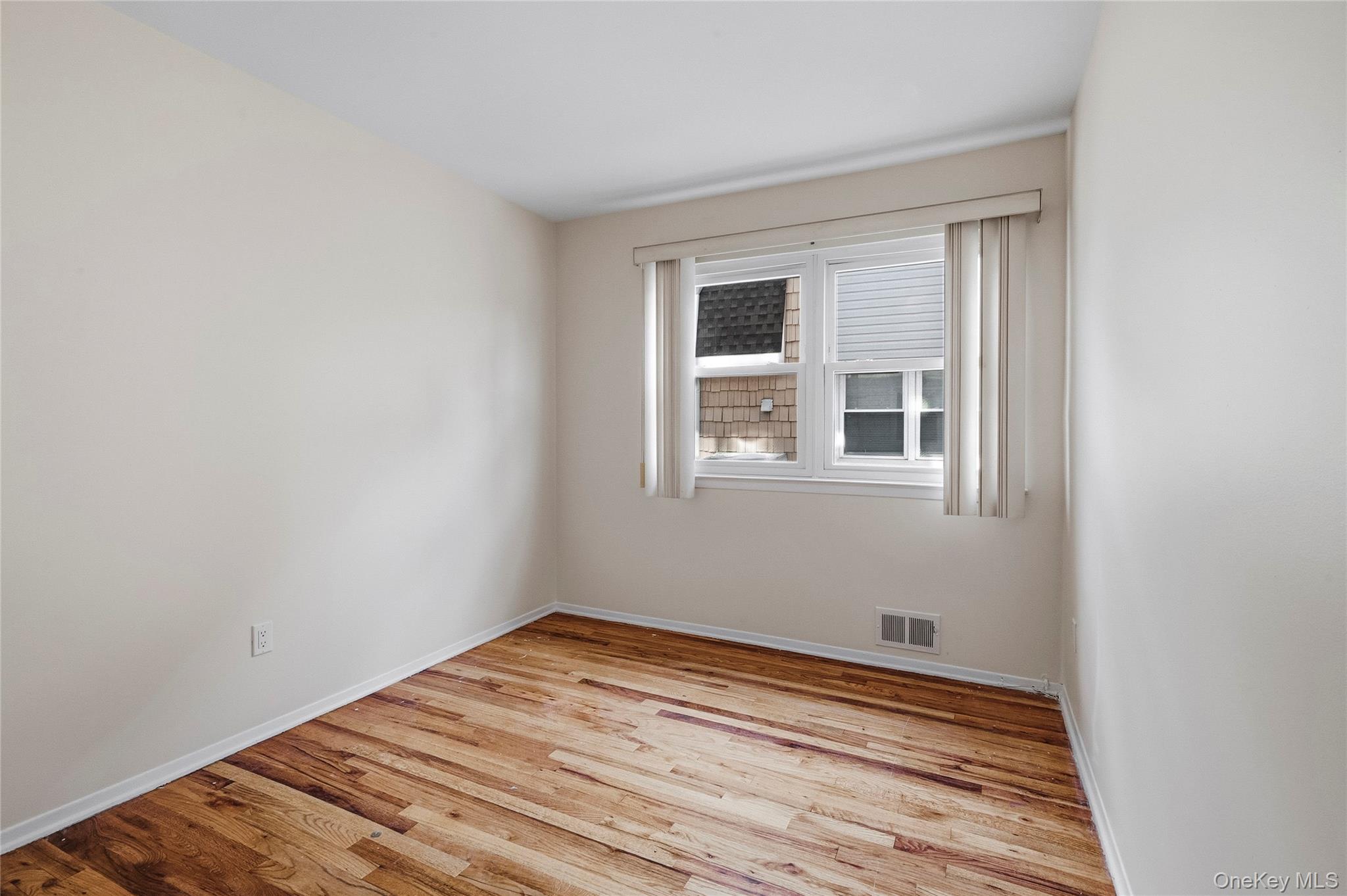 15-69 215th Street, Unit 1 Queens, NY 11360 - Photo 14 of 20 a view of empty room with wooden floor and fan