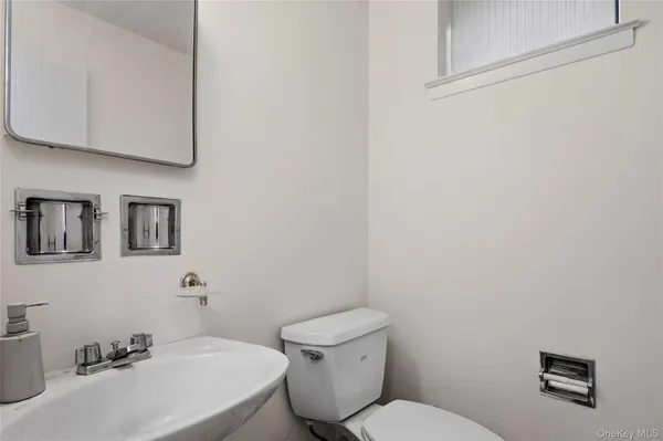 a bathroom with a toilet a sink and mirror
