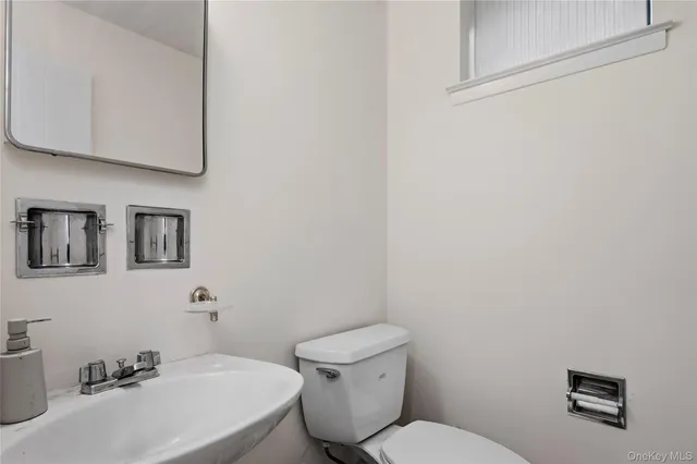 a bathroom with a toilet a sink and mirror