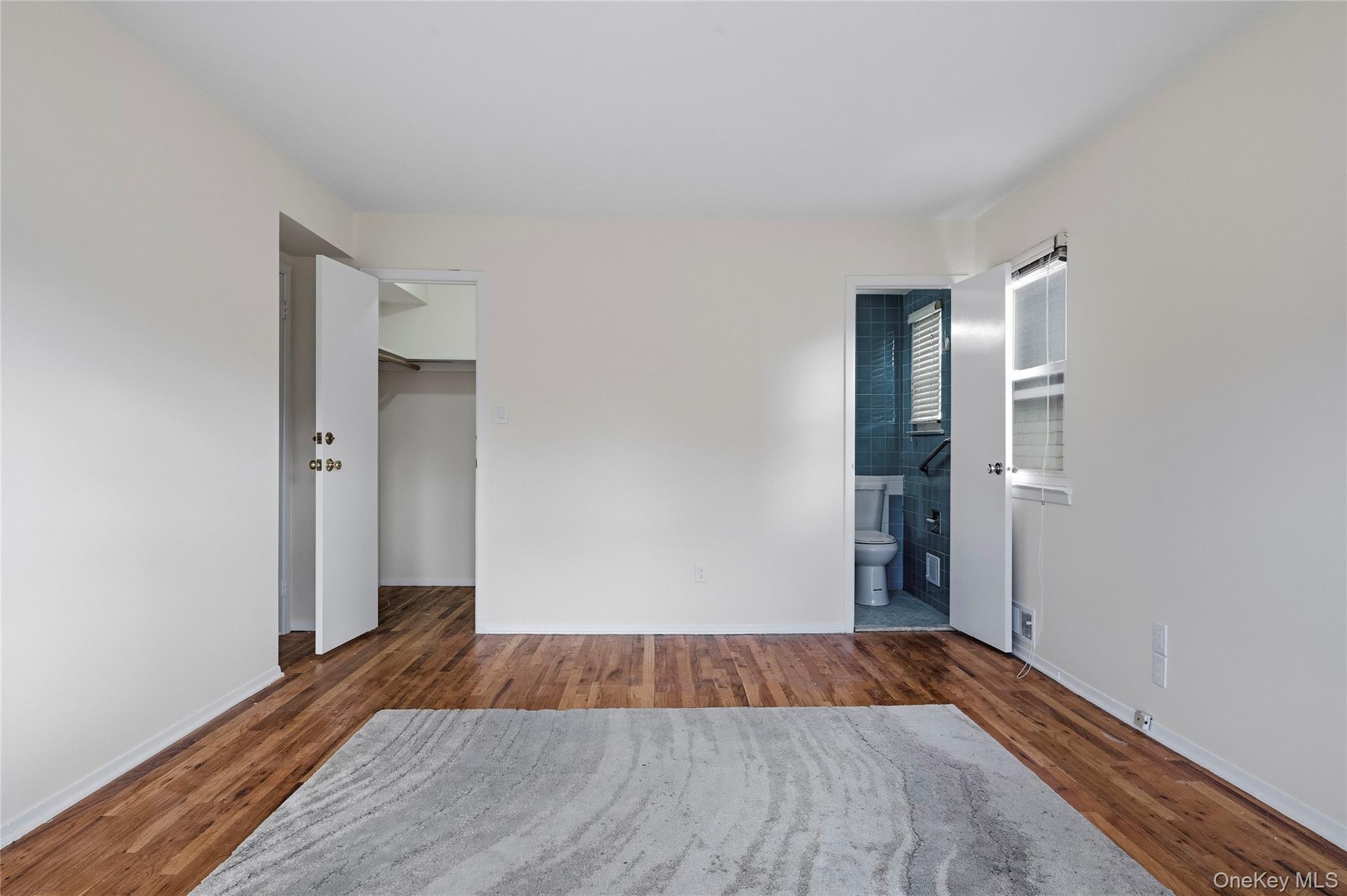 15-69 215th Street, Unit 1 Queens, NY 11360 - Photo 10 of 20 wooden floor in an empty room with a window
