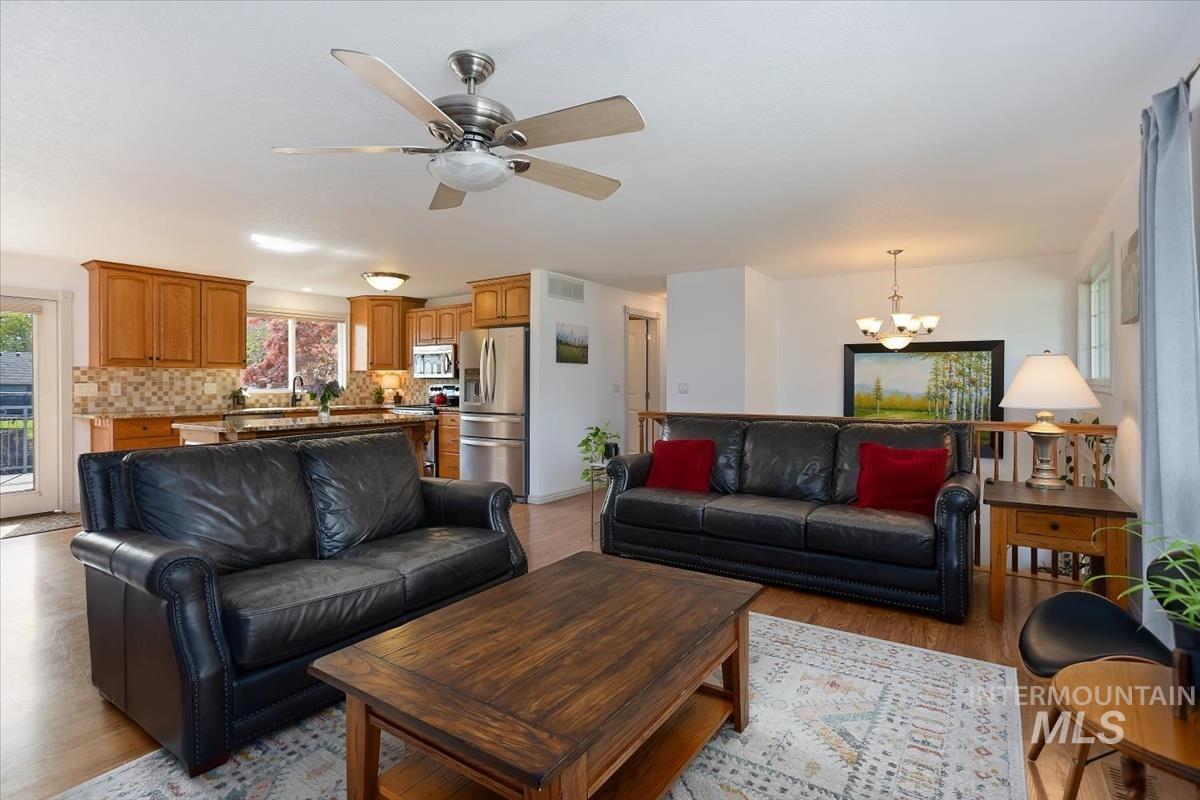 4870 North Farrow Street Boise, ID 83713 - Photo 11 of 40 Living room featuring hanging lights, a ceiling fan, and light wood-style flooring