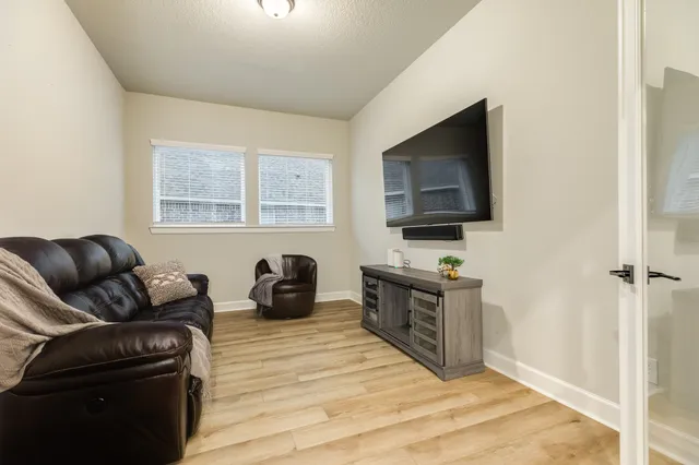 a living room with furniture and wooden floor