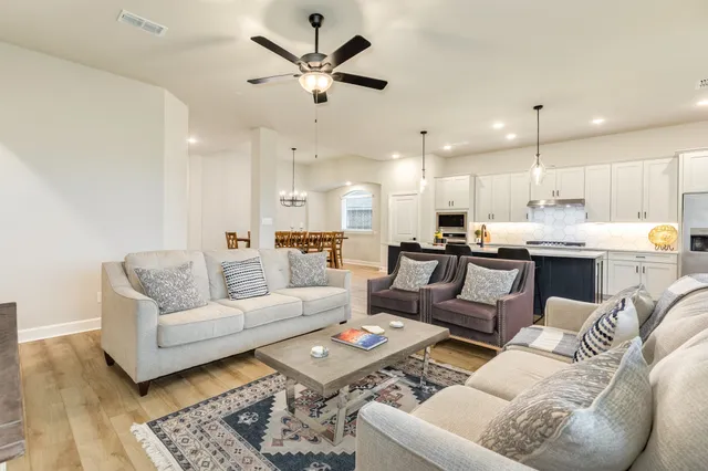 a large kitchen with stainless steel appliances a lot of counter space and a wooden floor