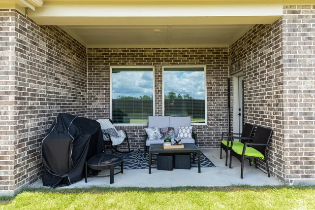 a front view of a house with a yard and potted plants
