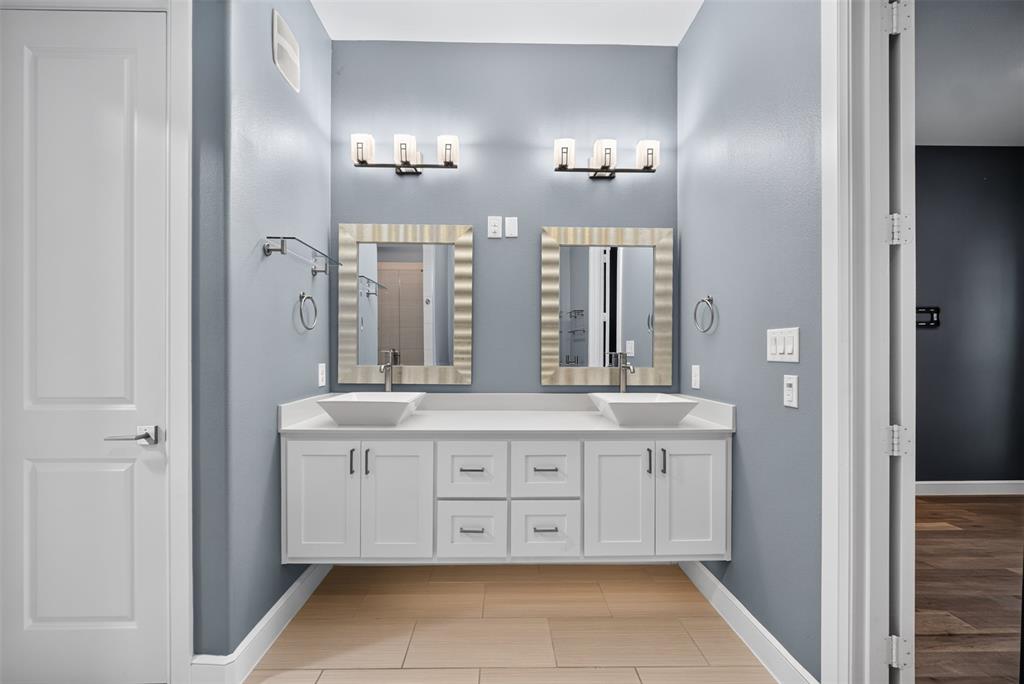 5015 Meridian Lane, Unit 2102 Addison, TX 75001 - Photo 24 of 36 Dual vessel sinks set on a floating white vanity with brushed nickel hardware