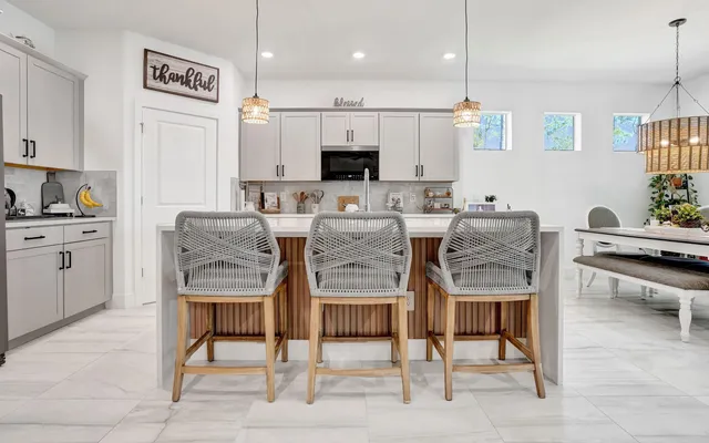 a dining room with furniture a rug and kitchen view