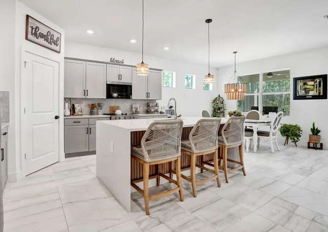 a large kitchen with a table chairs and a refrigerator