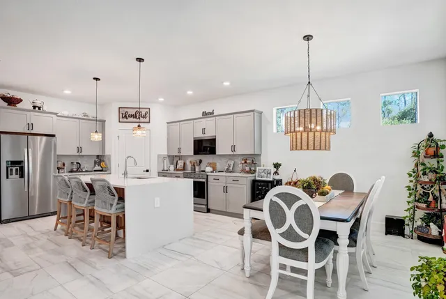 a kitchen with a dining table chairs and white cabinets
