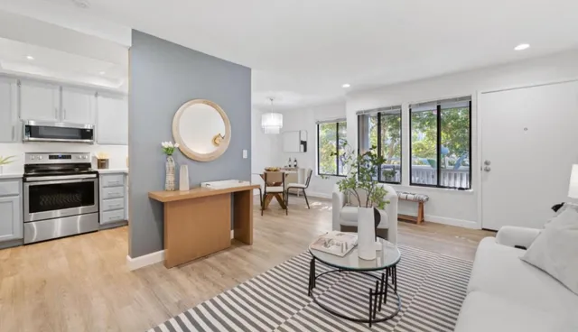 a living room with furniture a fireplace and a large window