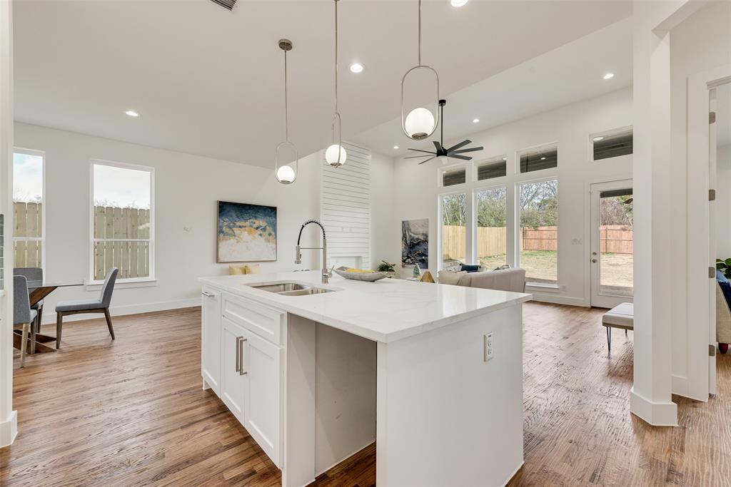 539 West Laureland Road Dallas, TX 75232 - Photo 17 of 37 a large kitchen with kitchen island a island a sink a stove and wooden floor