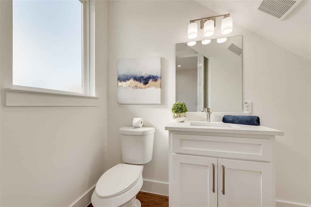 539 West Laureland Road Dallas, TX 75232 - Photo 19 of 37 a bathroom with a toilet a sink a mirror and vanity