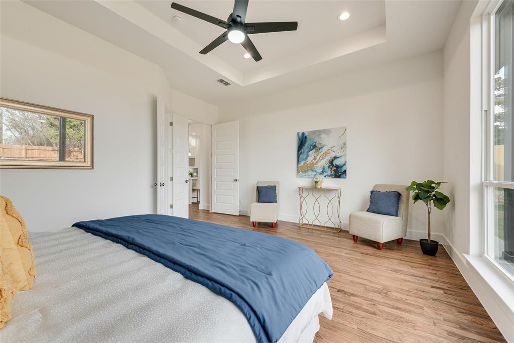 539 West Laureland Road Dallas, TX 75232 - Photo 24 of 37 a bedroom with a large bed and a chandelier