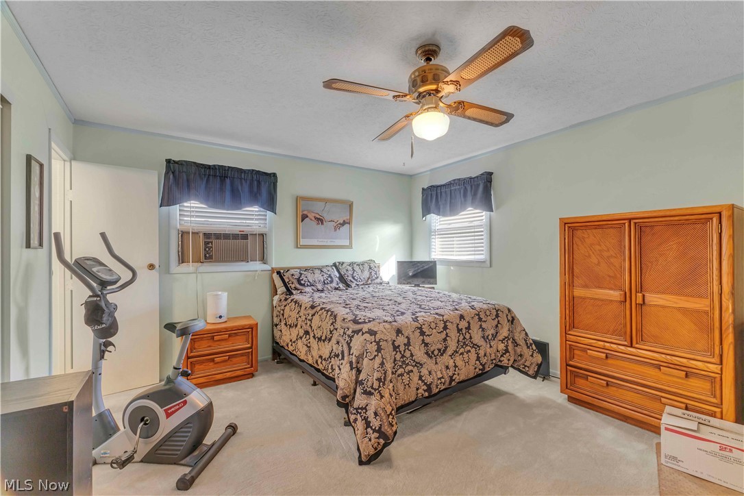 563 North Carpenter Road Brunswick, OH 44212 - Photo 21 of 45 Bedroom with a textured ceiling, light colored carpet, ceiling fan, and cooling unit