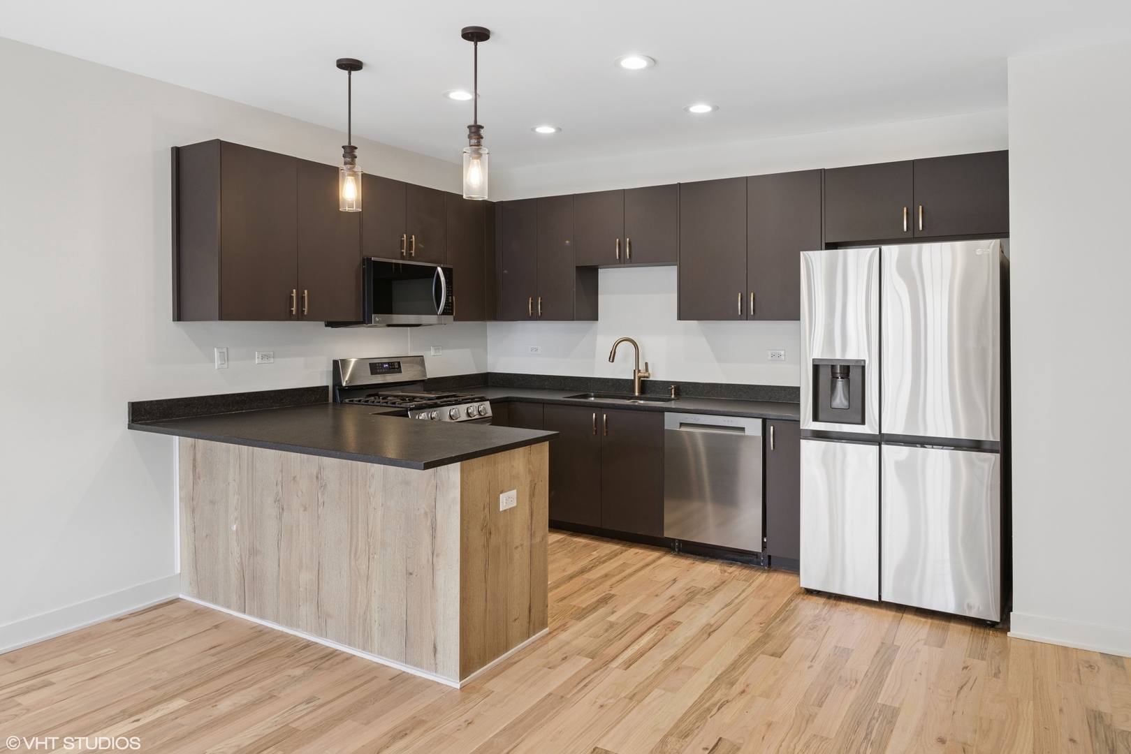 1246 South Fairfield Avenue, Unit 1 Chicago, IL 60608 - Photo 2 of 12 a kitchen with stainless steel appliances granite countertop a sink a stove a refrigerator and a microwave
