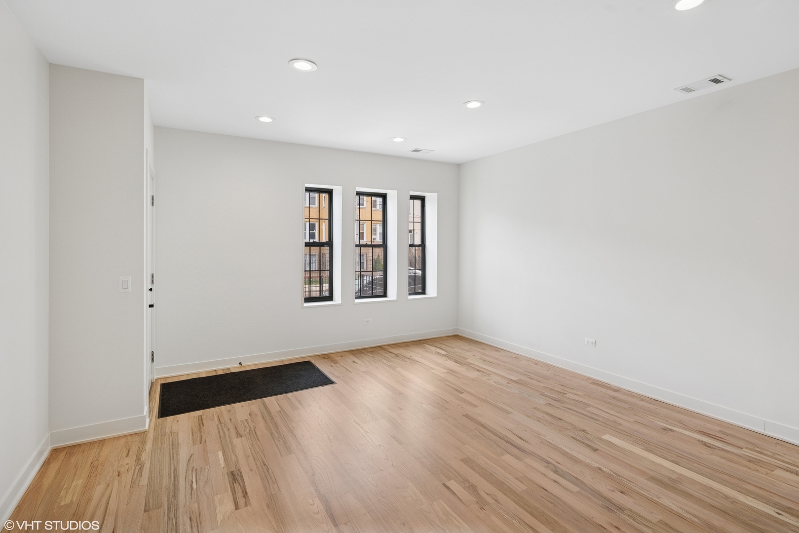 1246 South Fairfield Avenue, Unit 1 Chicago, IL 60608 - Photo 4 of 12 a view of an empty room with wooden floor and a window