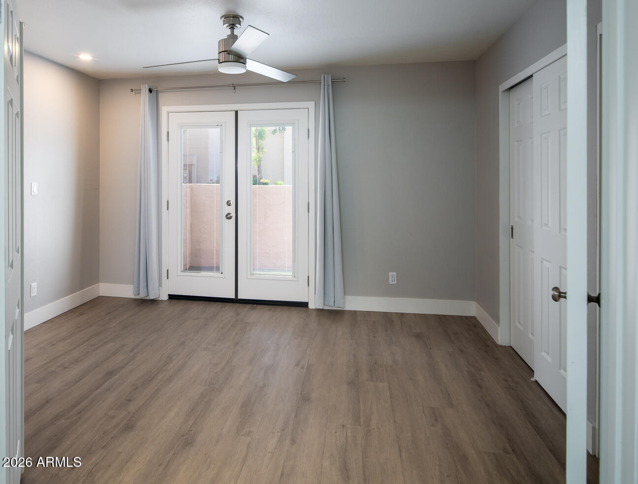 4540 North 44th Street, Unit 50 Phoenix, AZ 85018 - Photo 13 of 31 an empty room with wooden floor a ceiling fan and windows