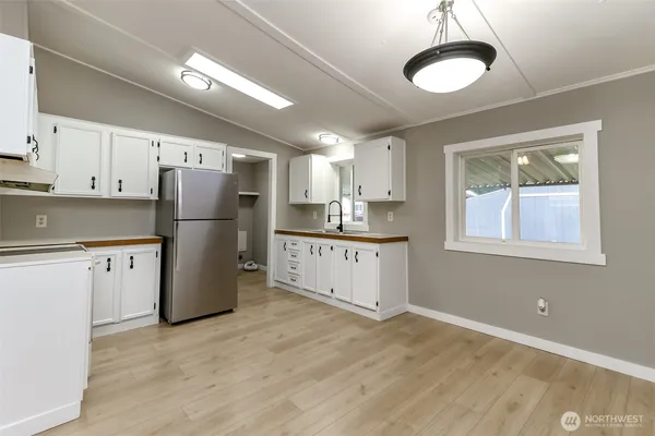 a view of an empty room with a kitchen